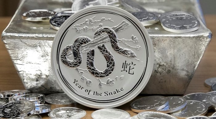 Year of the Snake ezüstérme 15 kilós ezüsttömb előtt, befektetési célú nemesfém kollekció részeként.