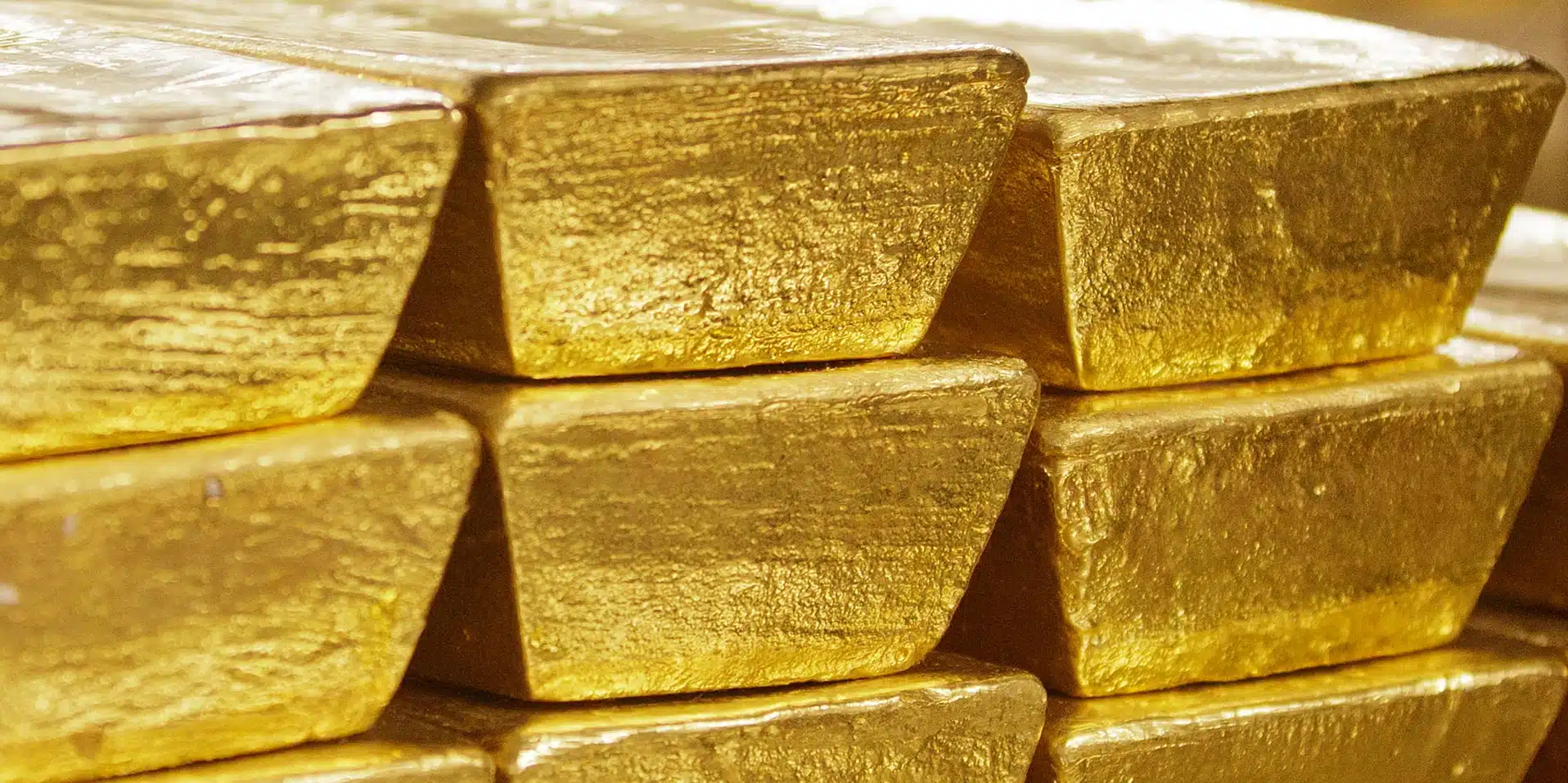 Egymásra rakott Good Delivery aranyrudak – befektetési arany fizikai tárolásának vizuális megjelenítése. Close-up of stacked Good Delivery gold bars, symbolizing physical investment-grade gold storage.